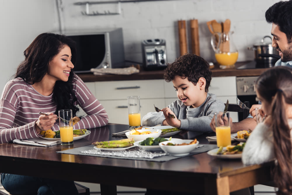 Família fazendo uma refeição na cozinha da casa
